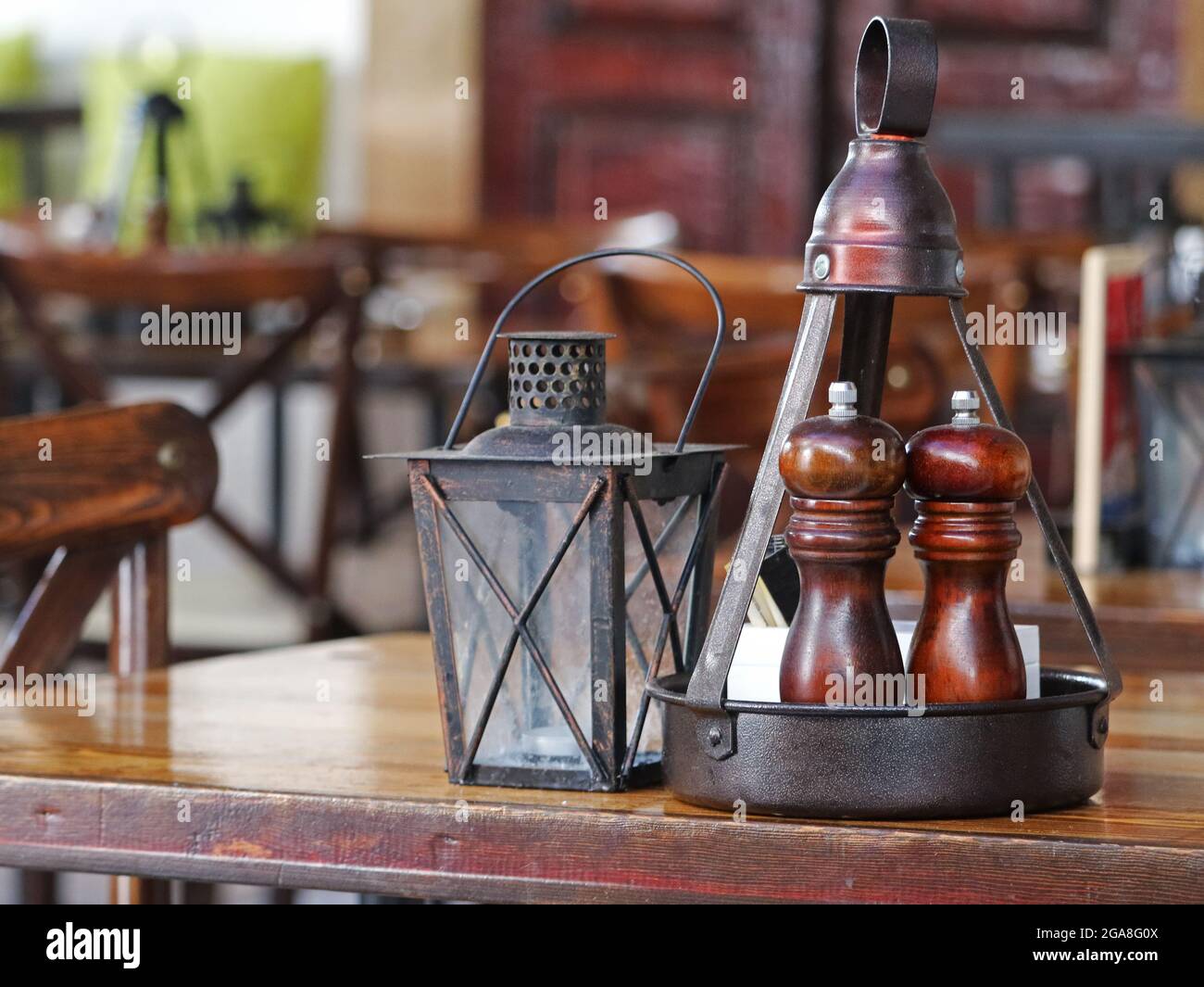 Salz- und Pfefferstreuer aus Holz auf einem alten braunen Holztisch in einem Restaurant Stockfoto