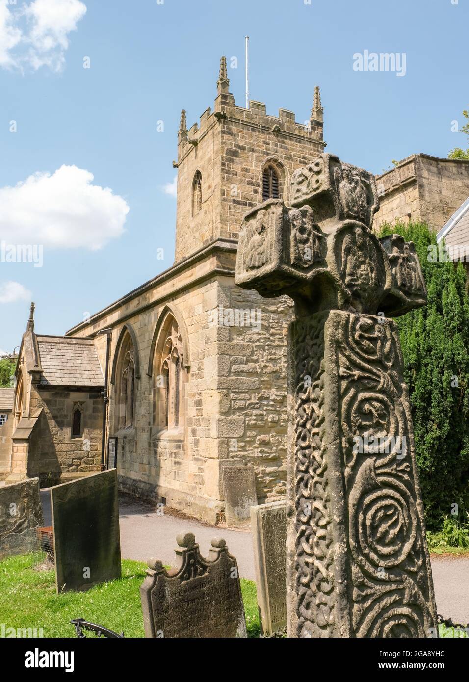 Das sächsische Kreuz, die Pfarrkirche und der Kirchhof im Pestdorf Eyam in Derbyshire. Stockfoto