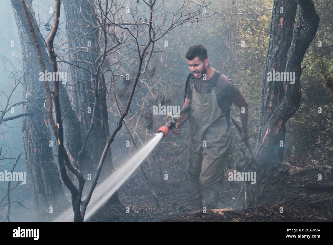 Akkar, Libanon. Juli 2021. Ein Mitglied der libanesischen Zivilverteidigung kämpft am 29. Juli 2021 in Akkar, Nordlibanon, gegen ein Wildfeuer. Das massive Feuer, das im nordlibanesischen Dorf Quubaiyat ausbrach, wütete in der Region noch am zweiten Tag, berichtete eine lokale Nachrichtenstelle am Donnerstag. Quelle: Khaled/Xinhua/Alamy Live News Stockfoto