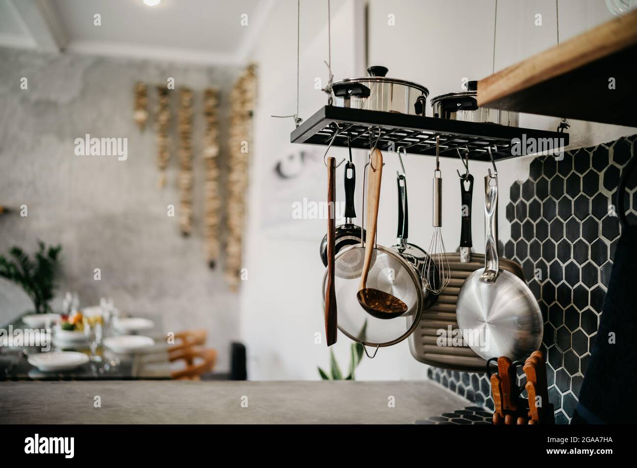 Das Design der modernen Wohnküche im Loft-Stil und rustikal. Schwarze Wand mit Regalen, Tabletts, Gläser, Tassen, Waschbecken Stockfoto