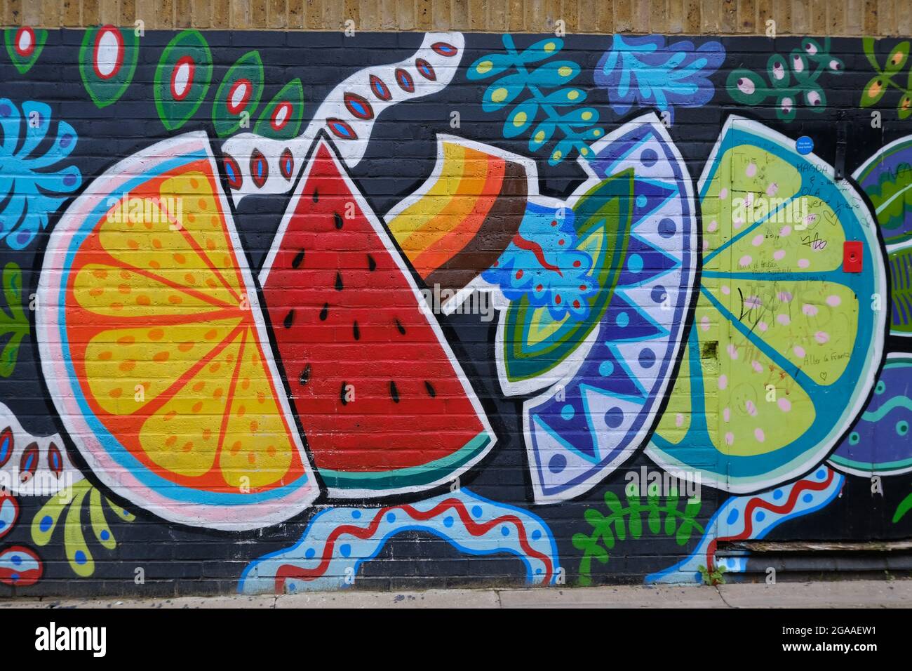 Buntes Street-Art-Stück eines unbekannten Künstlers in Camden mit Stücken verschiedener Früchte. Stockfoto