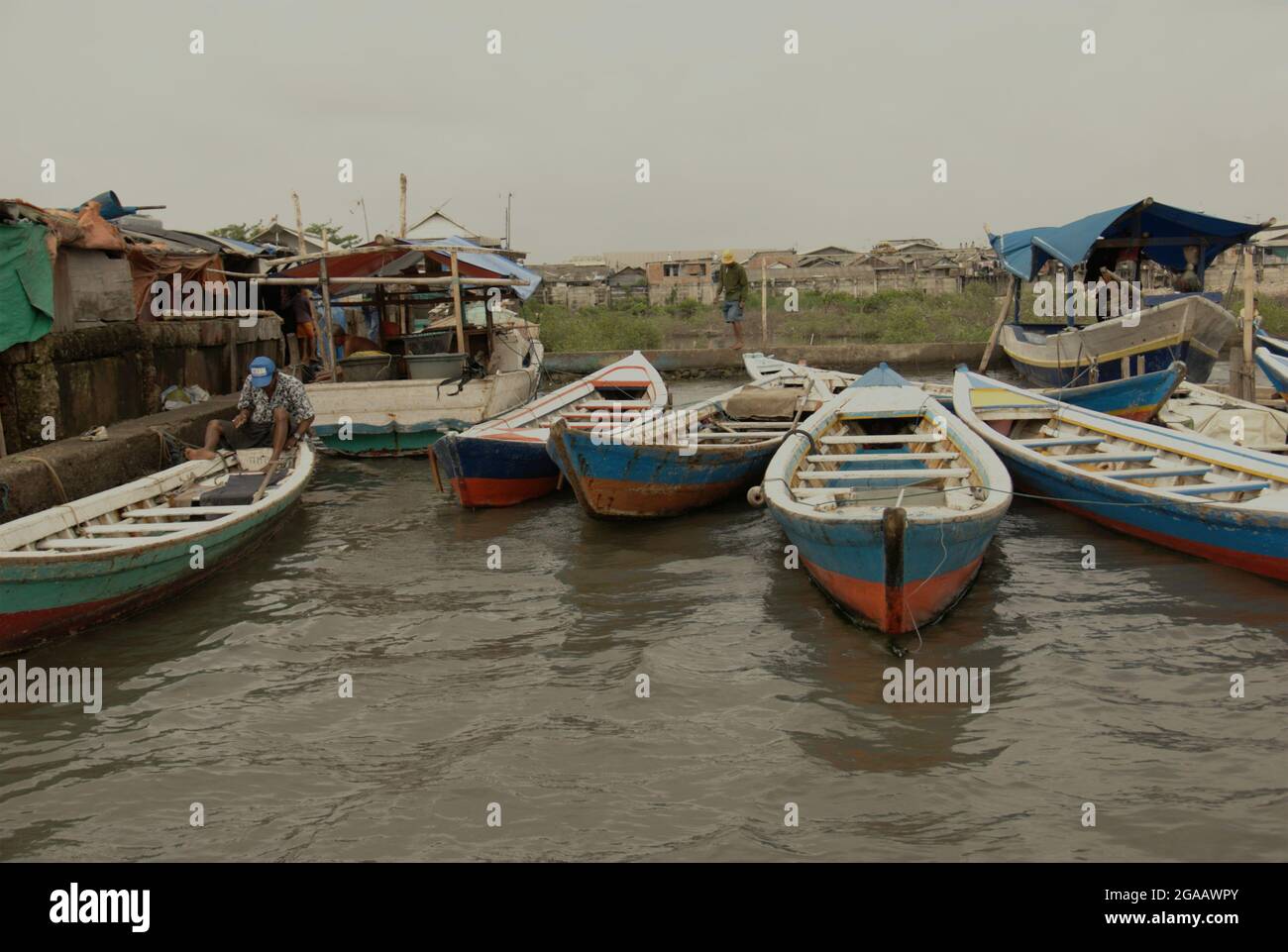 Holzboote sind an der Seite des Kanals am traditionellen Hafen Sunda Kelapa in Jakarta, Indonesien, gebunden. Stockfoto