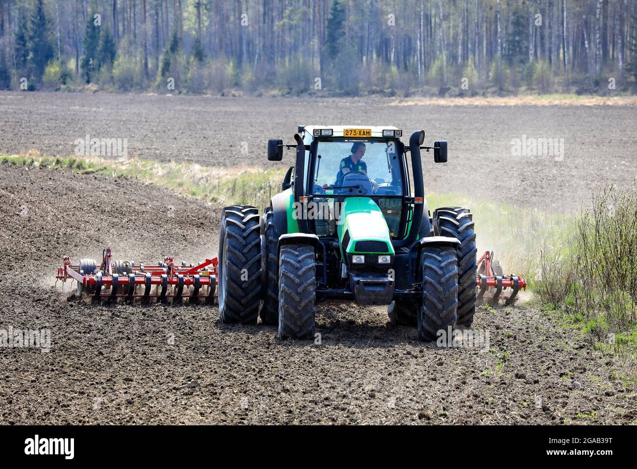 Landwirt kultiviert Feld mit grünen Deutz-Fahr Agrotron 135 Traktor und Vaderstad NZ aggressive Zinkenegge im Frühjahr. Salo, Finnland. 13.Mai 2021 Stockfoto
