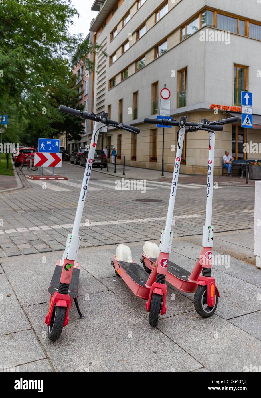 Ein Bild einer Gruppe von Elektrorollern von Hulaj, die auf dem Bürgersteig geparkt sind. Stockfoto