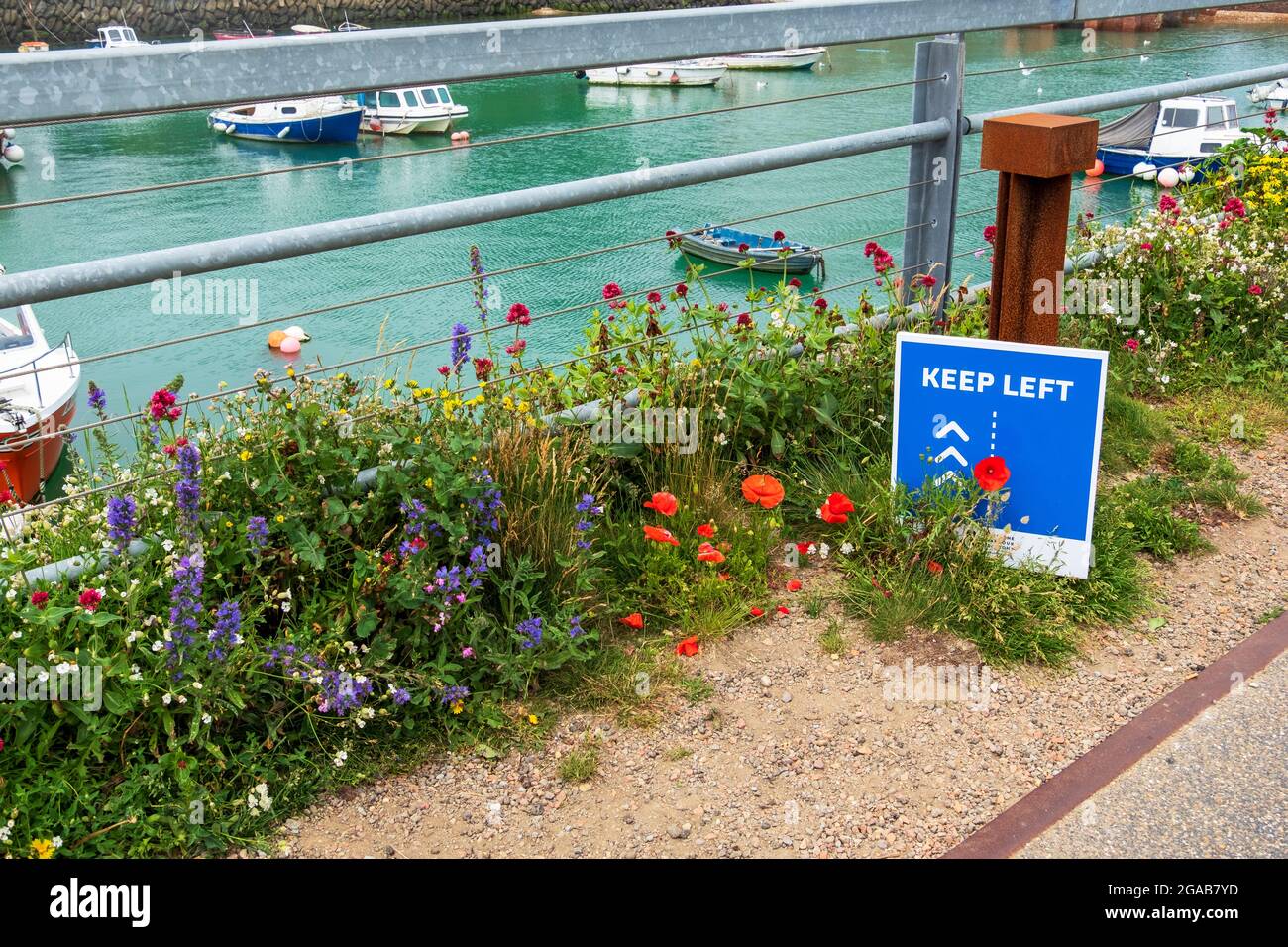 Covid-Hinweisschild für Fußgänger, sich links zu halten, nur in eine Richtung, auf dem Folkestone Harbour Viaduct. Kent, Großbritannien Stockfoto