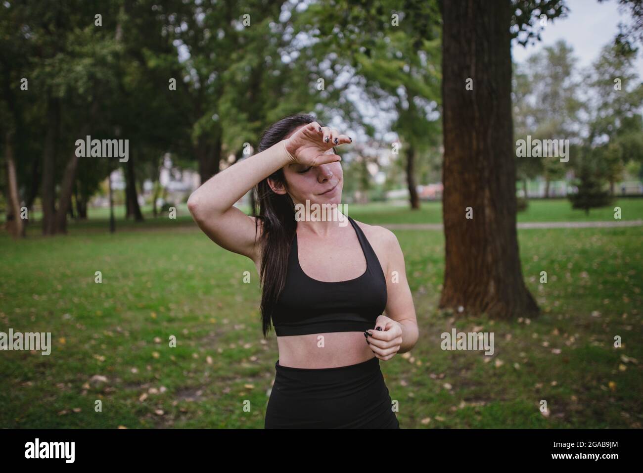 Junge Frau müde nach dem Training wischen Sie Schweiß Sport im Park Stockfoto