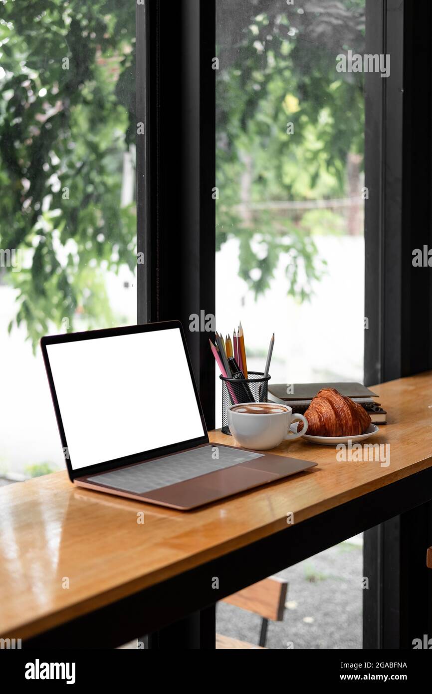 Arbeitsplatz, Laptop-Computer mit leerem weißen Bildschirm-Monitor auf dem Schreibtisch. Modell, Home Office-Konzept. Geschäft, von zu Hause aus arbeiten, studieren Stockfoto