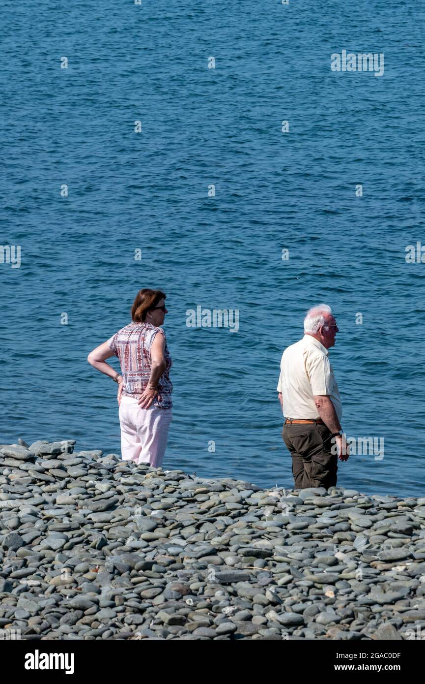 Älteres Paar zusammen an der Küste, Rentnerpaar am Strand, Paar mittleren Alters am Meer stehend, Paar stehend mit Blick aufs Meer, Stockfoto
