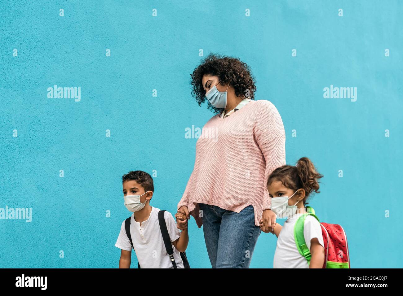 Mutter mit Sohn und Tochter zurück zur Schule, während sie Gesichtsschutzmaske während einer Coronavirus-Pandemie trug - Gesundheits- und Bildungskonzept Stockfoto