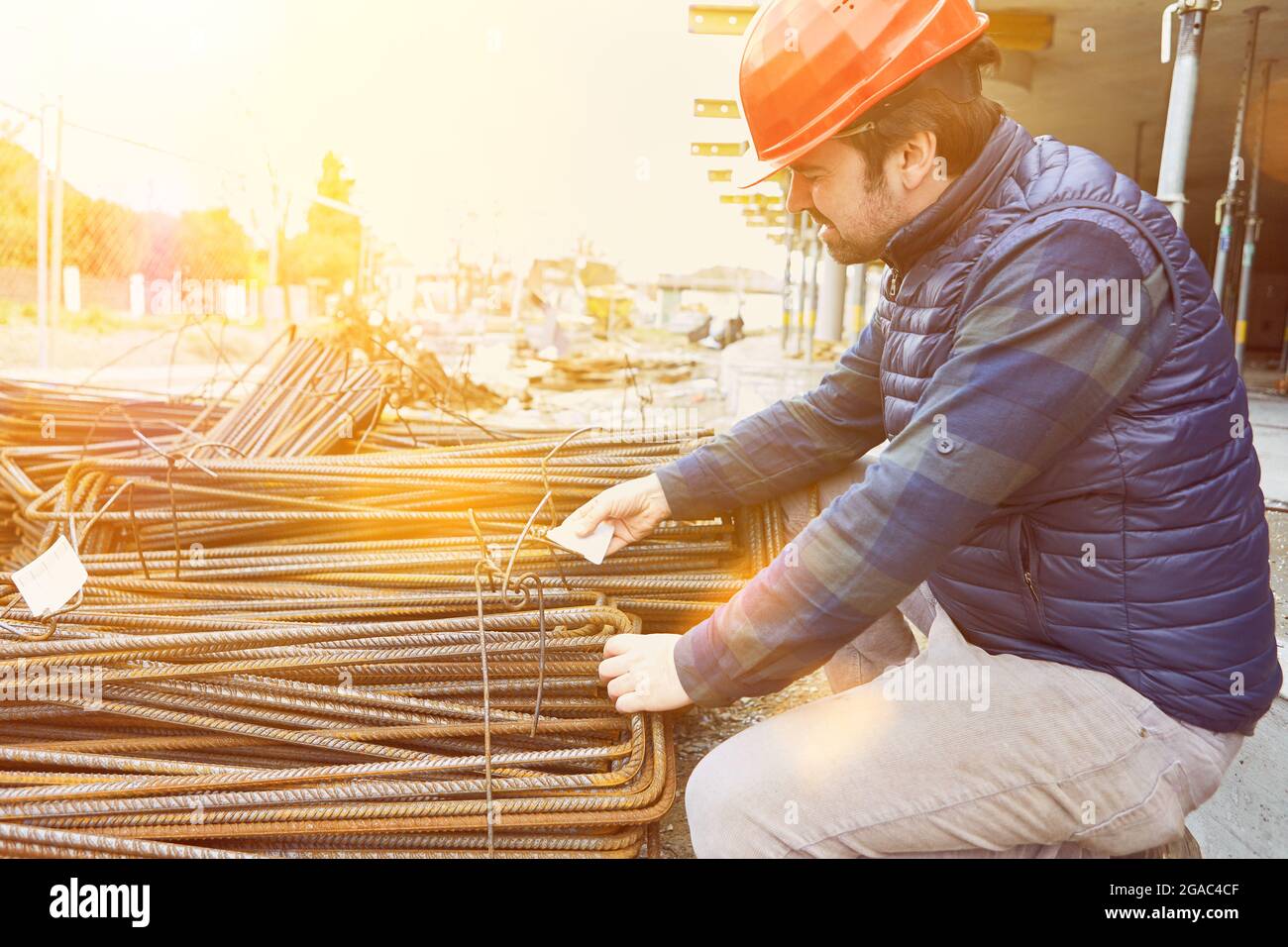 Arbeiter überprüft die Lieferung von Stahlverstärkung auf der Baustelle für einen Hausbau Stockfoto