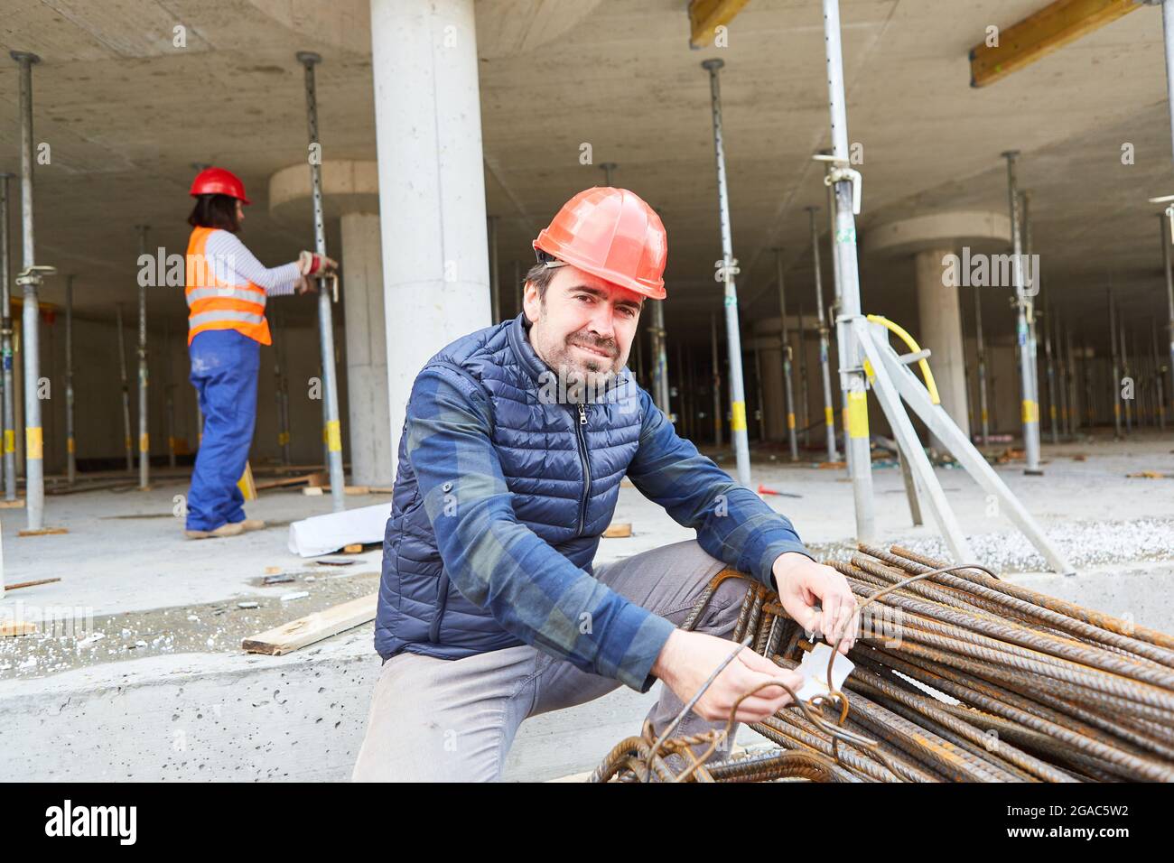 Handwerker als Vorarbeiter auf der Baustelle in der Gebäudehülle kontrolliert eine Lieferung von monier Eisen Stockfoto