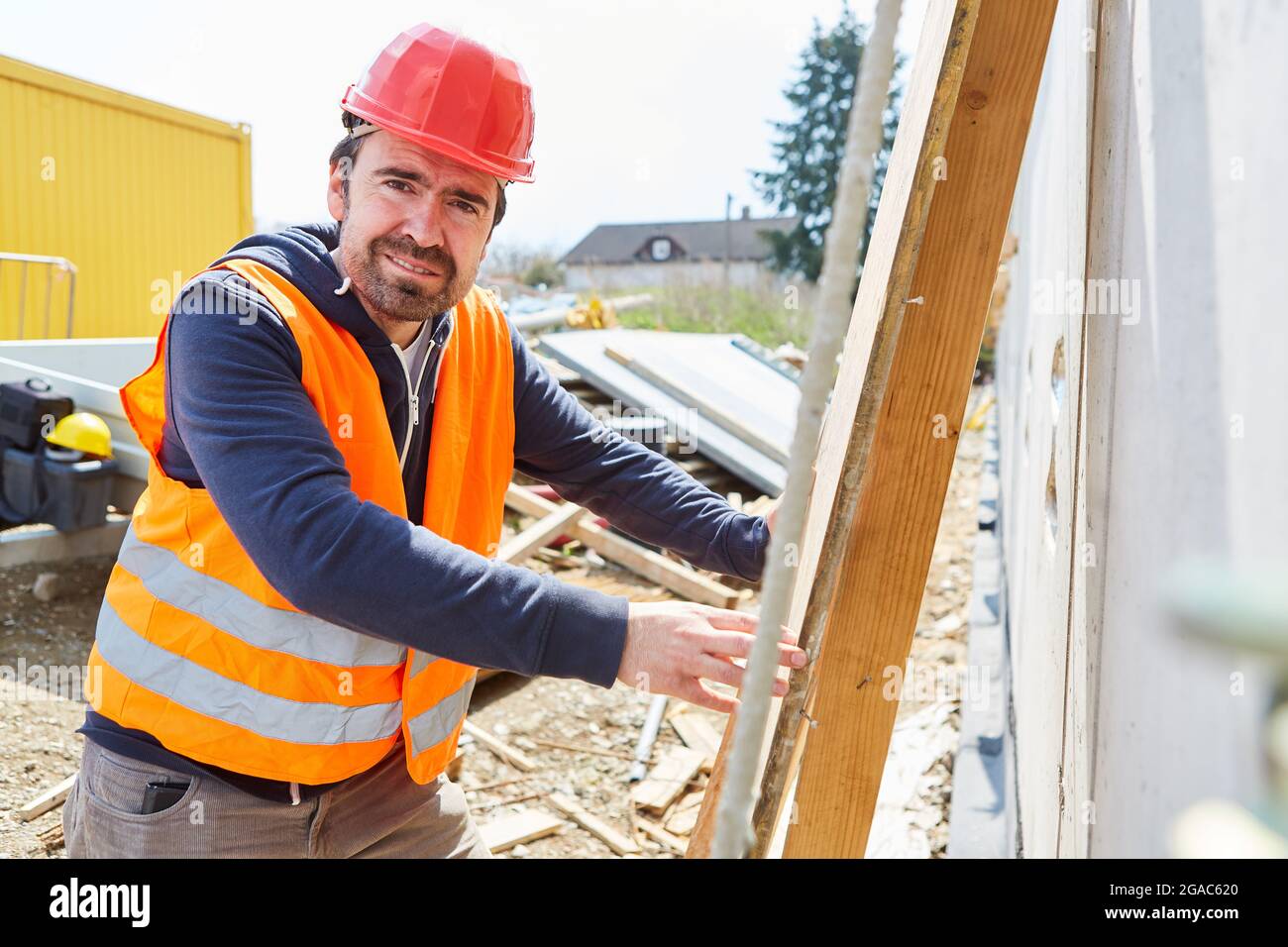 Bauarbeiter oder Zimmermann mit rotem Hut auf der Baustelle des Hauses Stockfoto