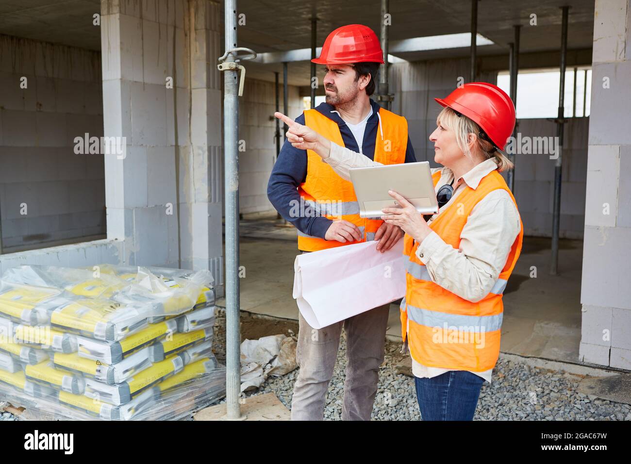 Architekt mit Tablet-Computer auf einer Baustelle während der Bauplanung mit dem Vorarbeiter Stockfoto