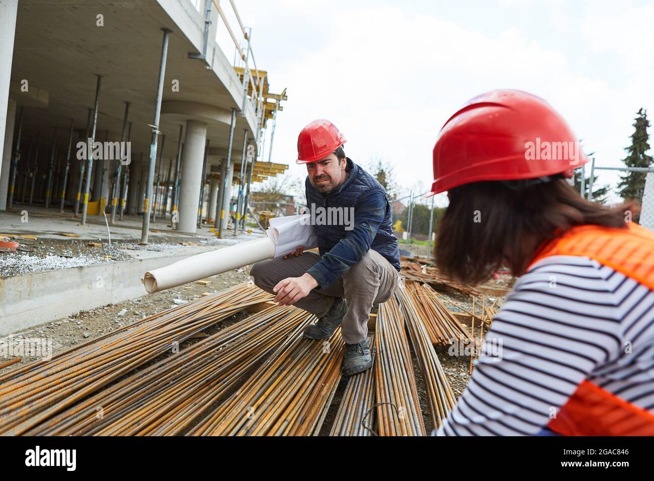 Architekt und Bauarbeiter bei der Qualitätskontrolle von Baustahl auf der Baustelle im Rohbau Stockfoto
