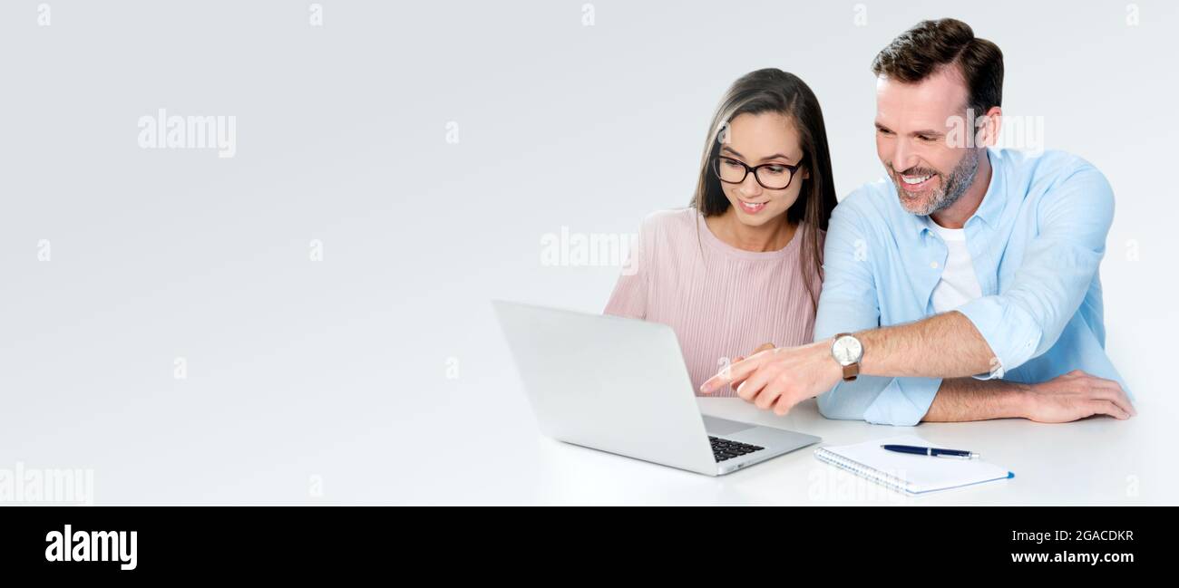 Lächelndes Paar sitzt am Computer. Finanzkonzept, schönes weißes Lächeln. Banner mit Kopierbereich Stockfoto
