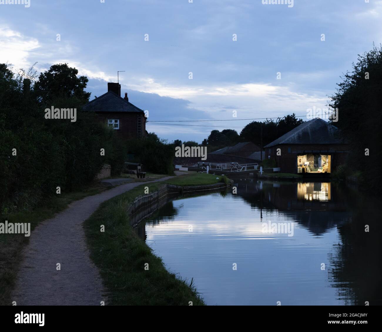 Braunston, Northamptonshire, Großbritannien, 29. Juli 2021: Licht beleuchtet das Innere einer Werkstatt am Canalside neben Schleusentoren am Grand Union Canal. Stockfoto