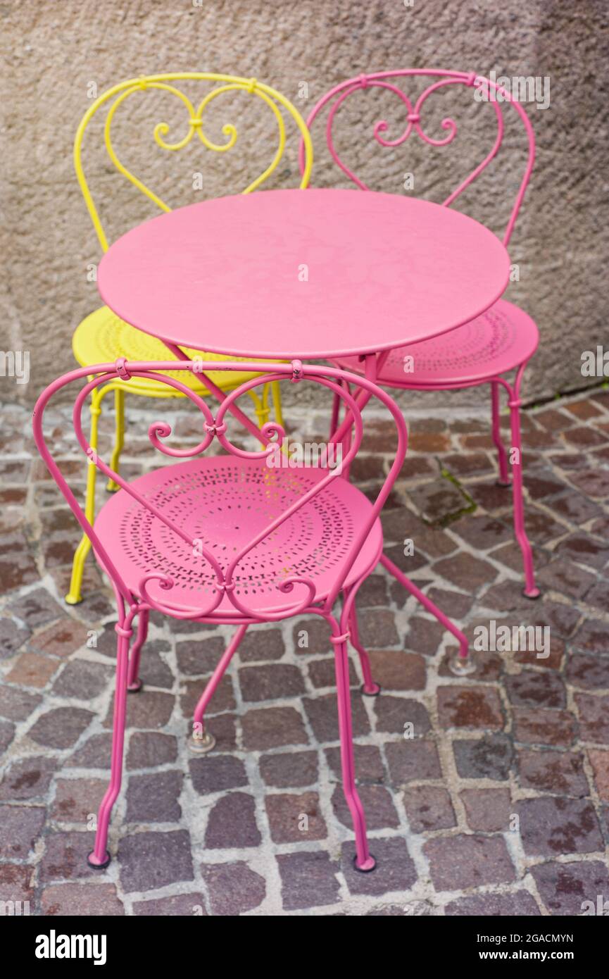 Wunderschöne rosa und gelbe Stühle im Straßencafé Stockfoto