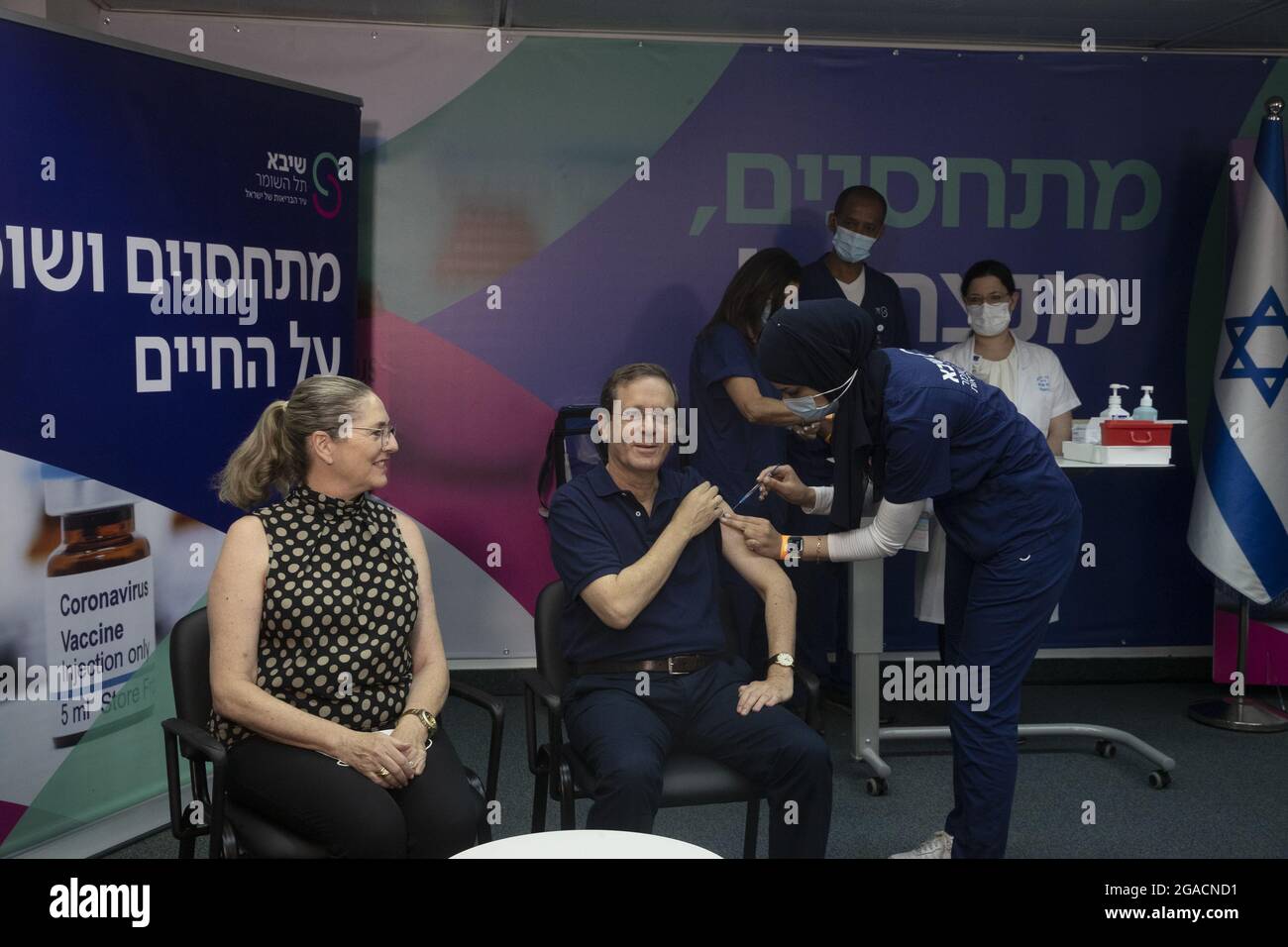 Ramat Gan, Israel. Juli 2021. Der israelische Präsident Isaac Herzog erhält am Freitag, den 30. Juli 2021, eine dritte Injektion eines Coronavirus-Impfstoffs, während seine Frau Michal, die sich nach links aufmachte, im Sheba Medical Center in Ramat Gan, Israel, reagiert. Pool Foto von Maya Alleruzzo/UPI Kredit: UPI/Alamy Live News Stockfoto