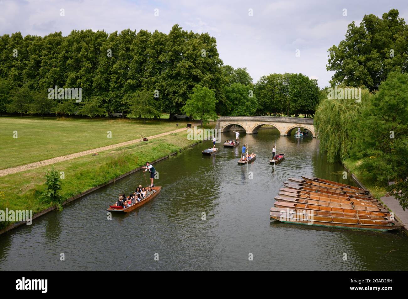 Touristen, die auf dem River Cam in Cambridge, England, poken, wobei die Trinity Bridge im Hintergrund zu sehen ist. Stockfoto