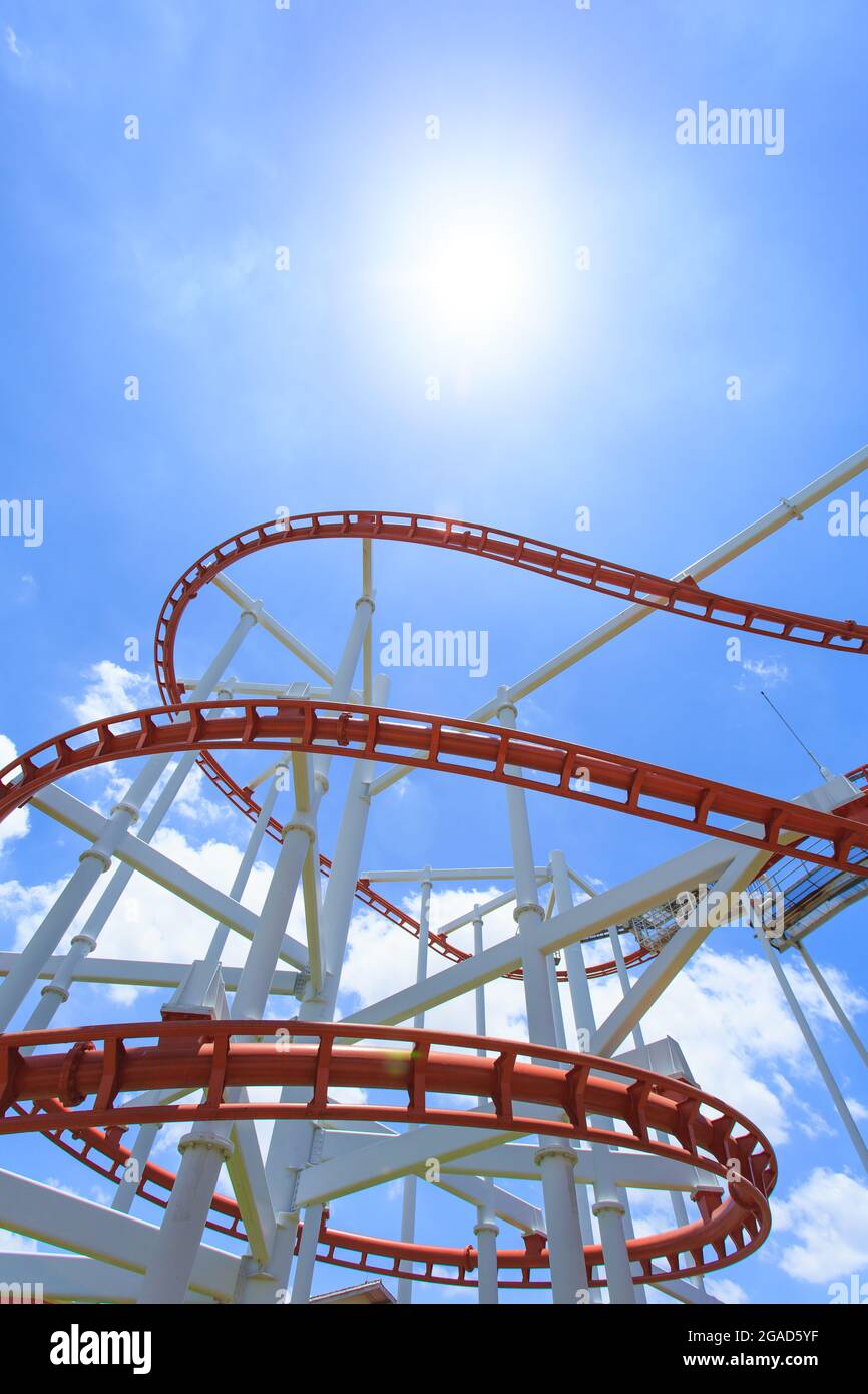 Rote Achterbahnlinie mit blauem Himmel im Hintergrund Stockfoto