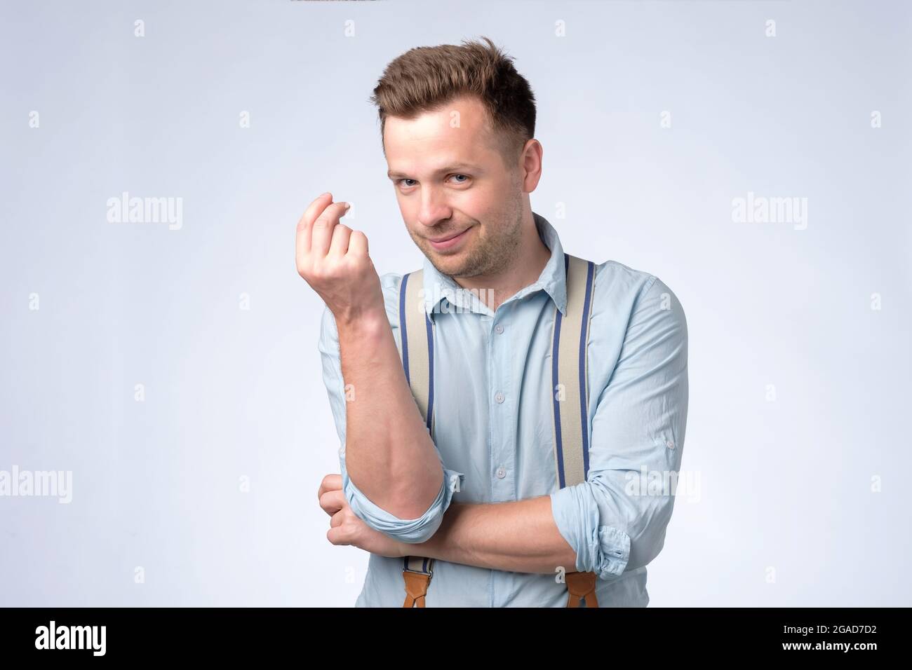 Kaukasischer Mann, der eine Pinch-Geste zeigt und bittet oder bettelt Stockfoto