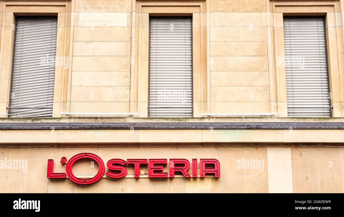 Retro-Logo eines italienischen Restaurants: „l'Osteria“ in Rot unter drei geschlossenen Fenstern. Gebäudefassade. Stockfoto