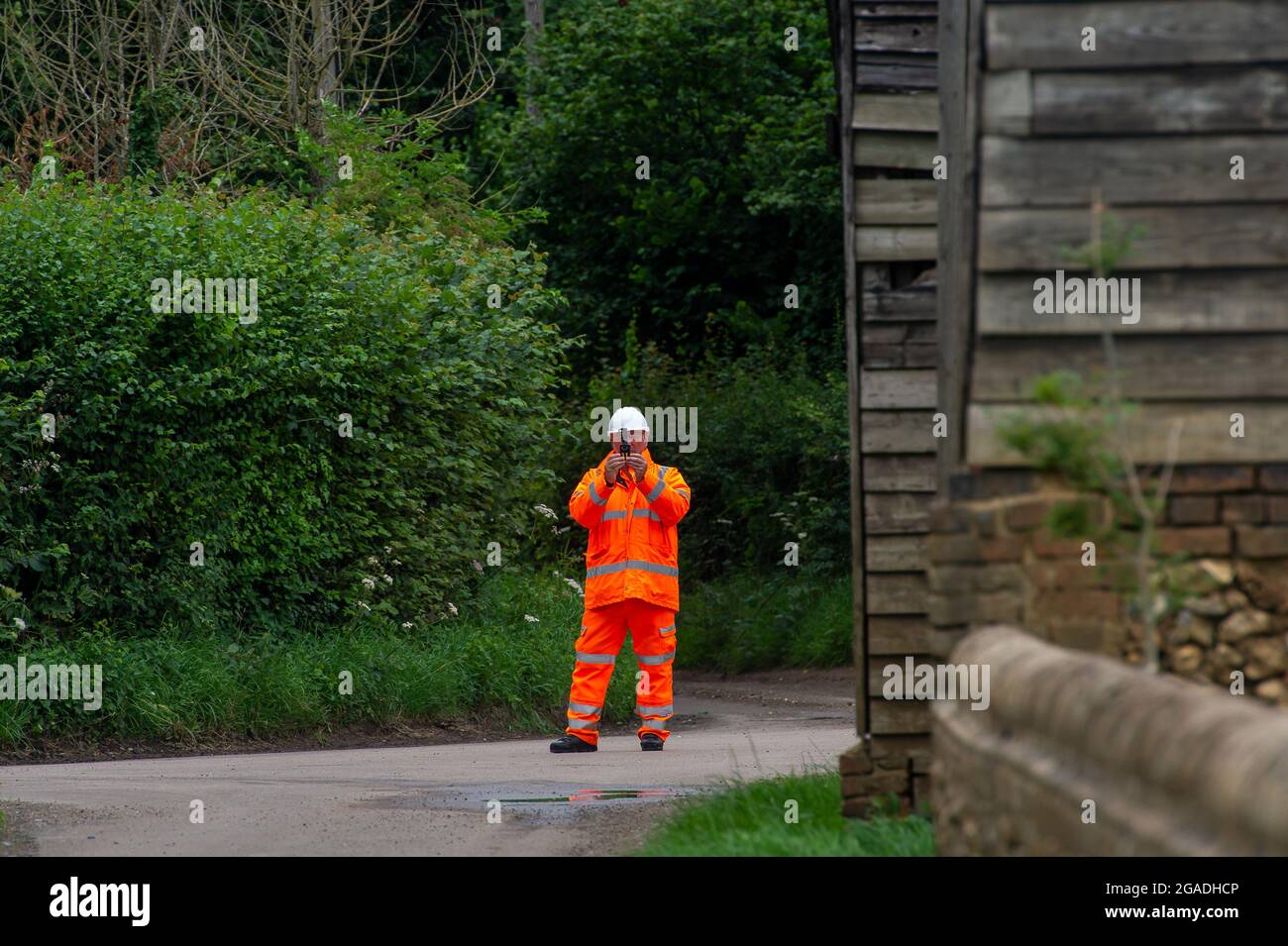 Aylesbury Valle, Buckinghamshire, Großbritannien. Juli 2021. Ein HS2-Sicherheitsbeamter filmt eine alleinreisende Frau, die auf einer öffentlichen Straße geht. Quelle: Maureen McLean/Alamy Stockfoto