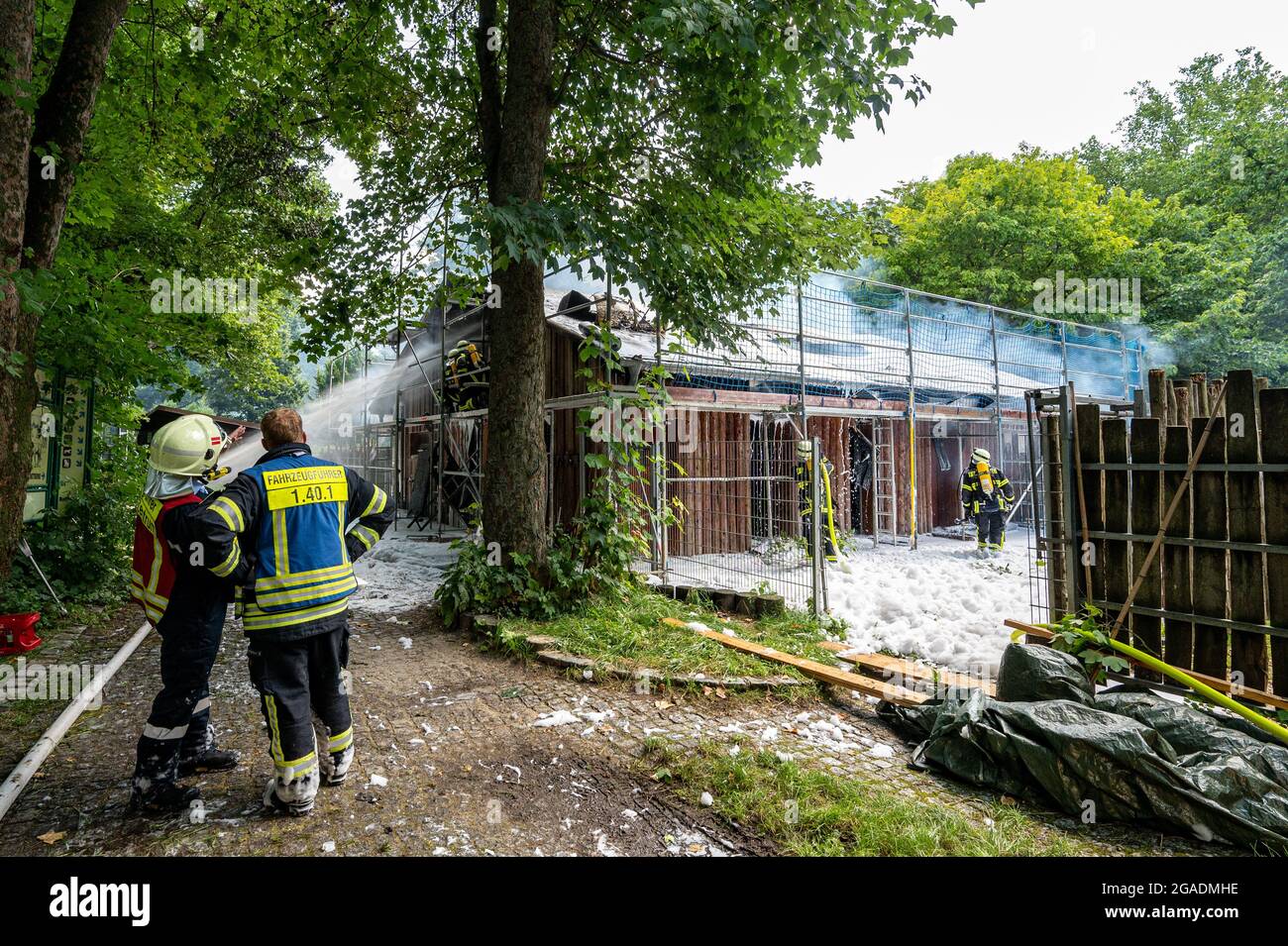 Straubing, Deutschland. Juli 2021. Feuerwehrleute löschen das Feuer in einem Gebäude auf dem Gelände des Zoos. Tiere und Menschen seien nicht in Gefahr, sagte die Feuerwehr. Es gab jedoch eine starke Entwicklung von Rauch. Quelle: Armin Weigel/dpa/Alamy Live News Stockfoto