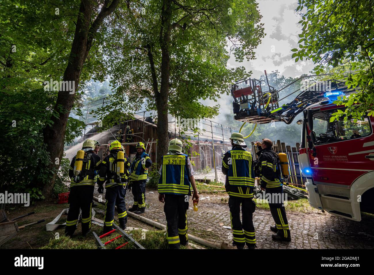 Straubing, Deutschland. Juli 2021. Feuerwehrleute löschen das Feuer in einem Gebäude auf dem Gelände des Zoos. Tiere und Menschen seien nicht in Gefahr, sagte die Feuerwehr. Es gab jedoch eine starke Entwicklung von Rauch. Quelle: Armin Weigel/dpa/Alamy Live News Stockfoto