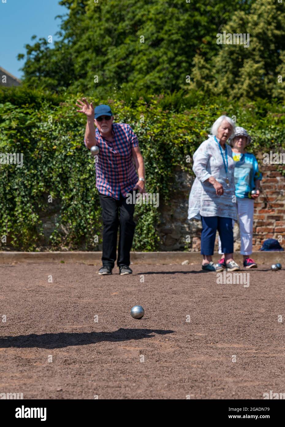 Senioren, ältere Menschen oder Rentner, die im Sommer bei Sonnenschein Petanque oder Boule spielen, Haddington, East Lothian, Schottland, Großbritannien Stockfoto