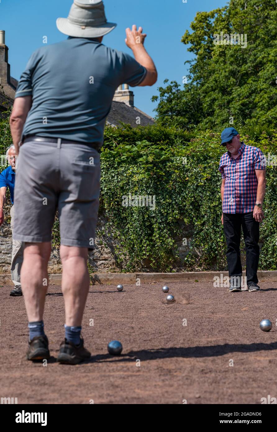 Senioren, ältere Menschen oder Rentner, die im Sommer bei Sonnenschein Petanque oder Boule spielen, Haddington, East Lothian, Schottland, Großbritannien Stockfoto