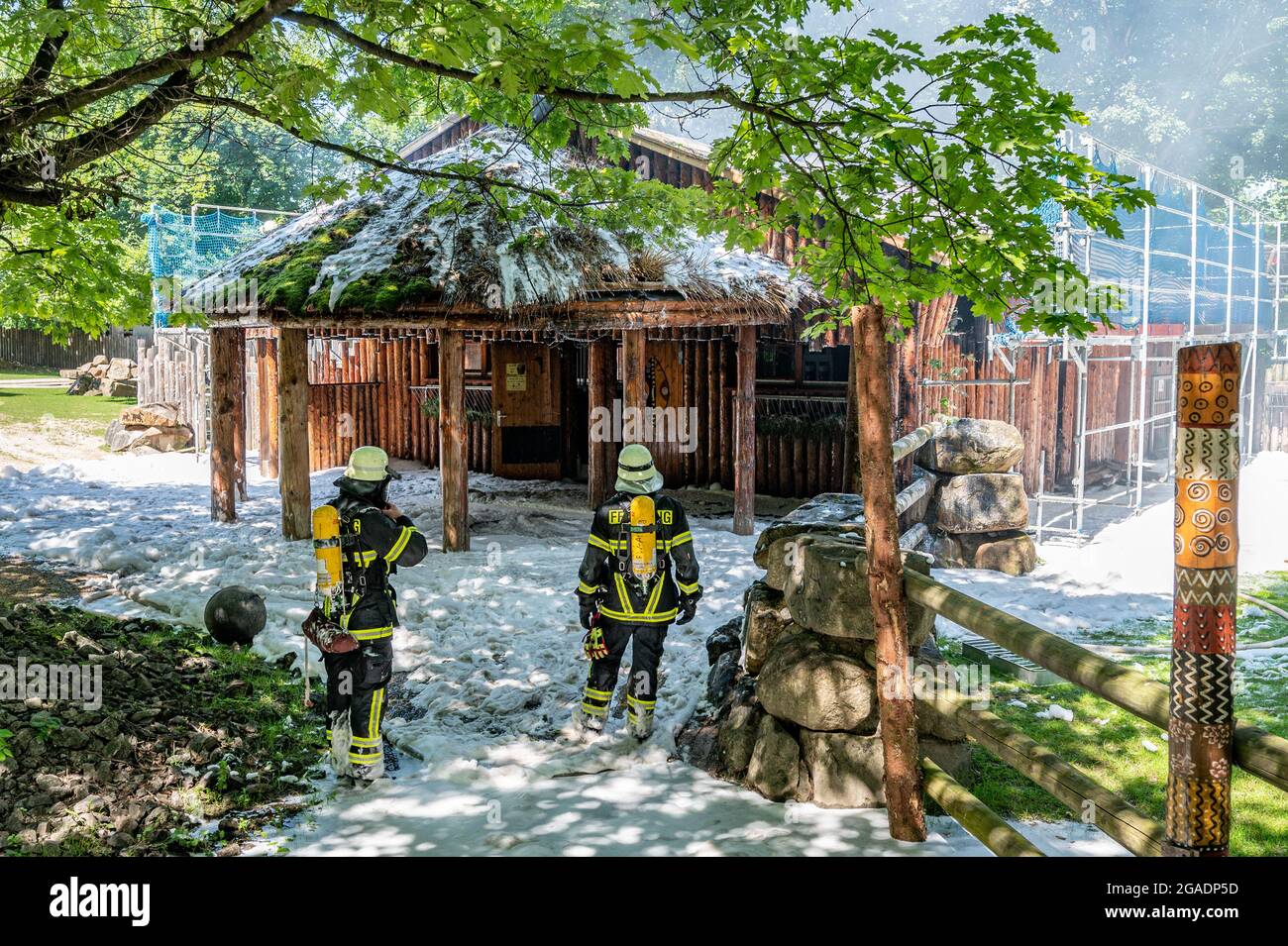 Straubing, Deutschland. Juli 2021. Feuerwehrleute löschen das Feuer in einem Gebäude auf dem Gelände des Zoos. Tiere und Menschen seien nicht in Gefahr, sagte die Feuerwehr. Es gab jedoch eine starke Entwicklung von Rauch. Quelle: Armin Weigel/dpa/Alamy Live News Stockfoto