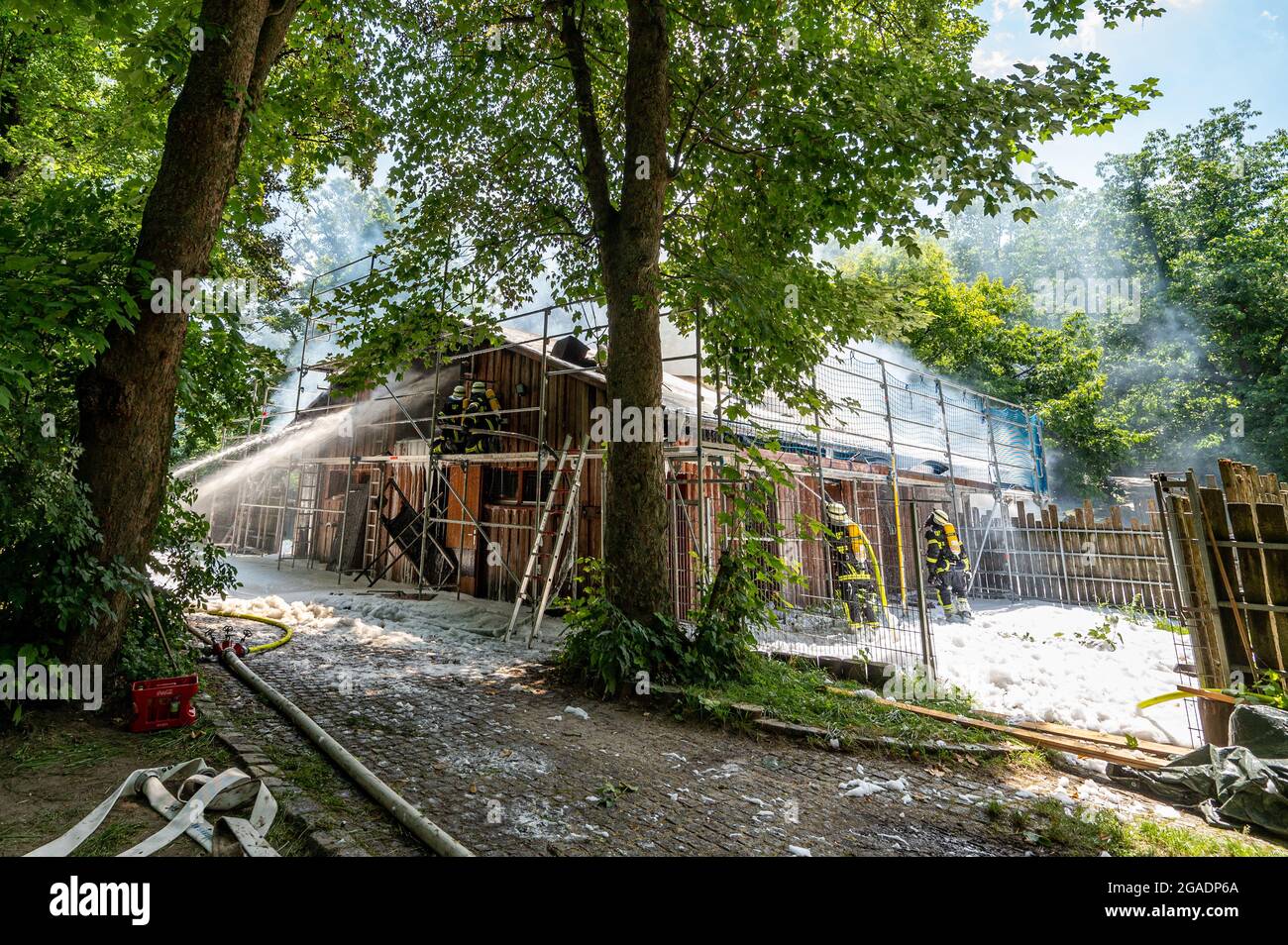 Straubing, Deutschland. Juli 2021. Feuerwehrleute löschen das Feuer in einem Gebäude auf dem Gelände des Zoos. Tiere und Menschen seien nicht in Gefahr, sagte die Feuerwehr. Es gab jedoch eine starke Entwicklung von Rauch. Quelle: Armin Weigel/dpa/Alamy Live News Stockfoto