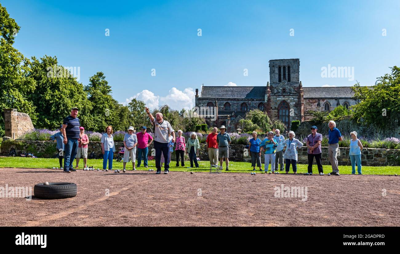 Ältere Menschen oder Rentner, die in Summer Sunshine, Haddington, East Lothian, Schottland, Großbritannien, eine Coaching-Lektion beim Spielen von Boule oder Petanque haben Stockfoto