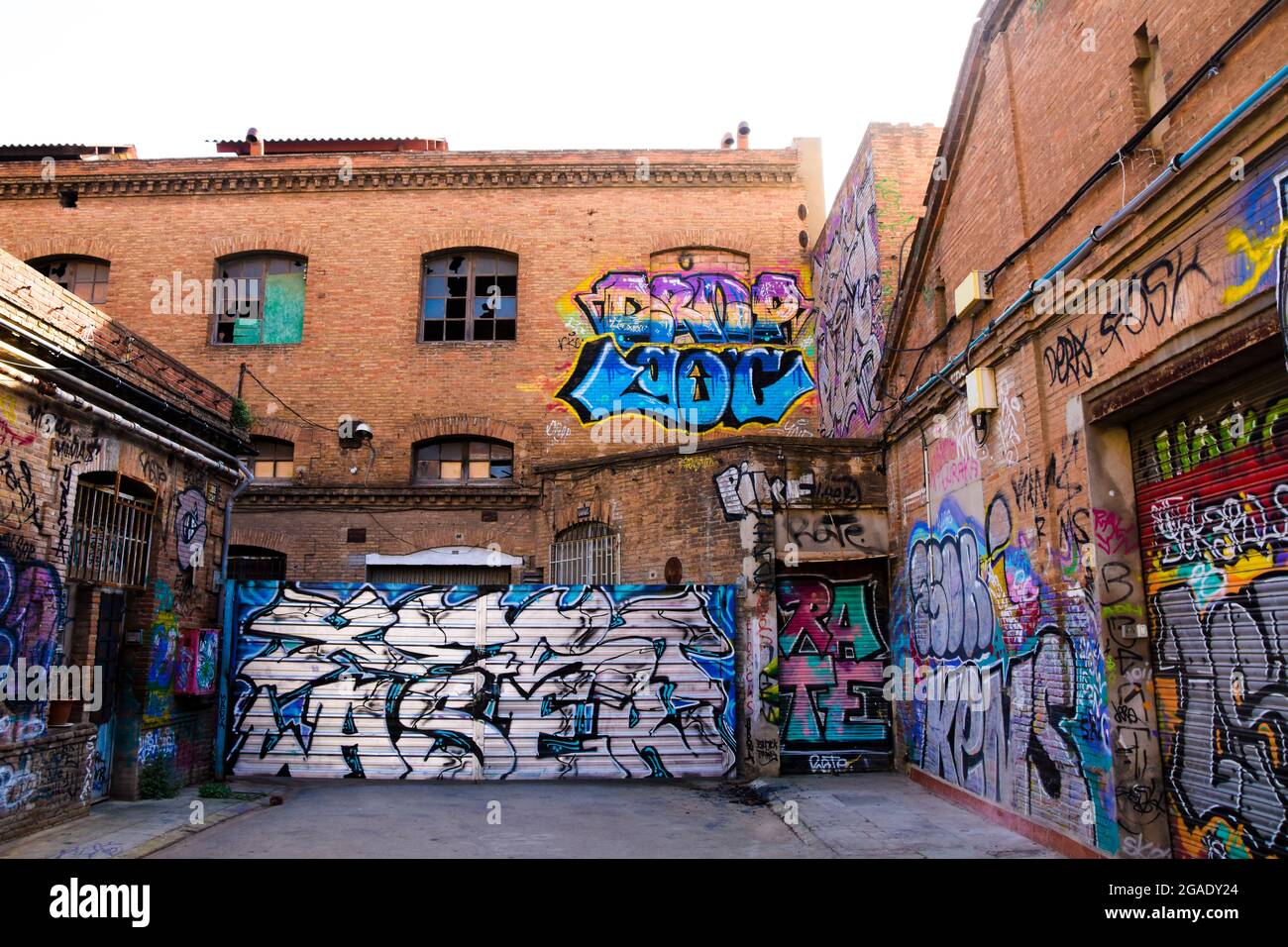 Graffitis auf roten Ziegelwänden einer alten Fabrik. Stockfoto