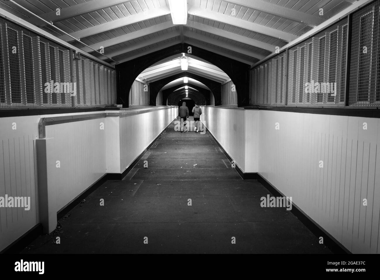 Zwei männliche Jugendliche gehen über die Dana-Fußgängerbrücke am Bahnhof Shrewsbury, Shropshire, England, Großbritannien Stockfoto