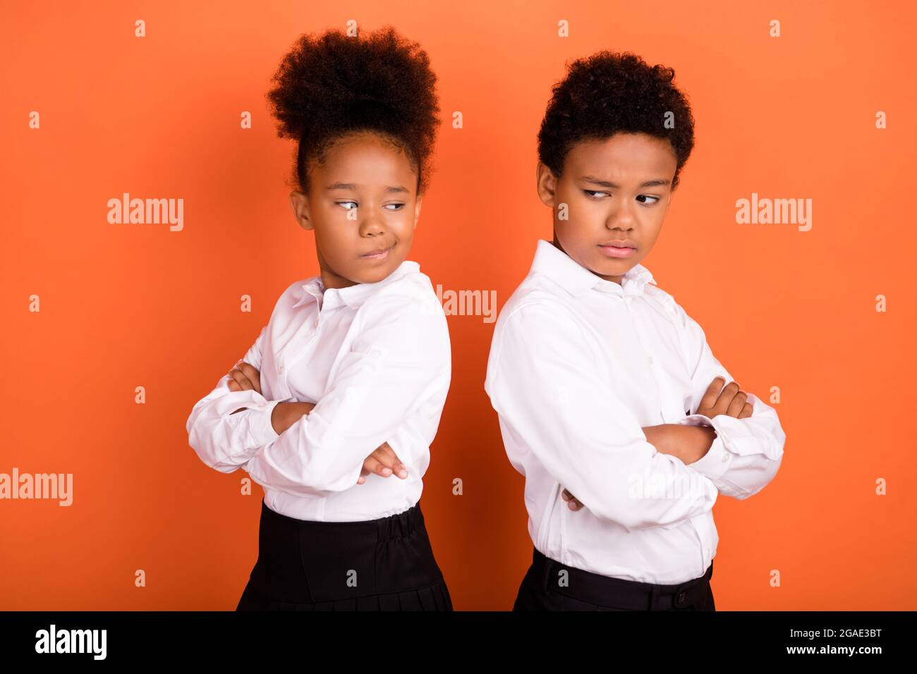 Profil Seitenfoto von zwei jungen schwarzen Kindern gefalteten Händen unglücklich beleidigt Konflikt isoliert über orange Farbe Hintergrund Stockfoto