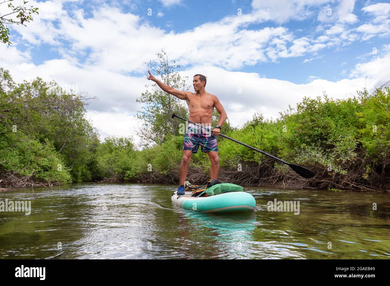 Abenteuerliche hispanische Erwachsene Athletic man Paddle Boarding Stockfoto