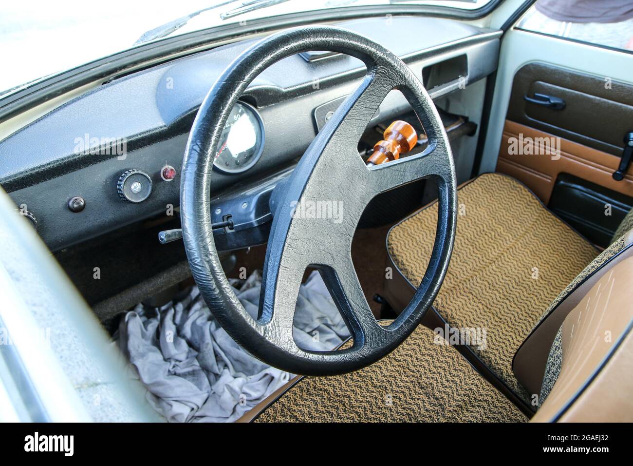 Das schlichte Interieur des Oldtimer aus der sozialistischen Ära. Das Lenkrad mit dem Armaturenbrett und den braunen Sitzen sind sichtbar. Stockfoto