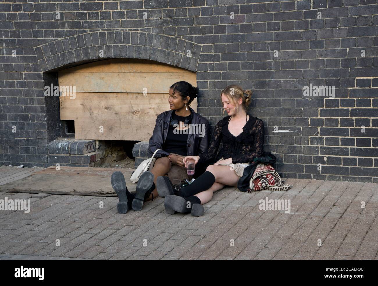 Zwei Absolventinnen vor einer Ausstellung für Kunsthochschüler in der Truman Brewery, London, England, Großbritannien Stockfoto