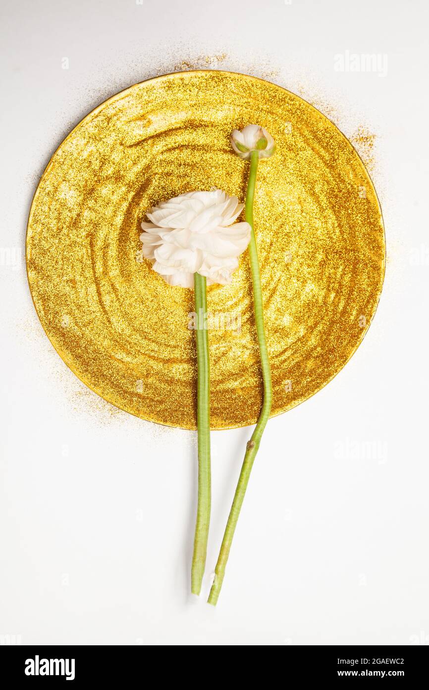 Frische weiße Pfingstrosen auf runden goldenen Teller Stockfoto