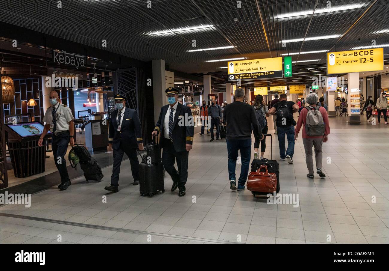 Amsterdam, New York, Niederlande. Juli 2021. Amsterdam, Niederlande - 29. Juli 2021: Reisende wandern durch den Flughafen Shiphol. Vollständig geimpfte Reisende dürfen während einer Pandemie reisen, müssen aber auf Flughäfen und in Flugzeugen Masken tragen. (Bild: © Lev Radin/ZUMA Press Wire) Stockfoto