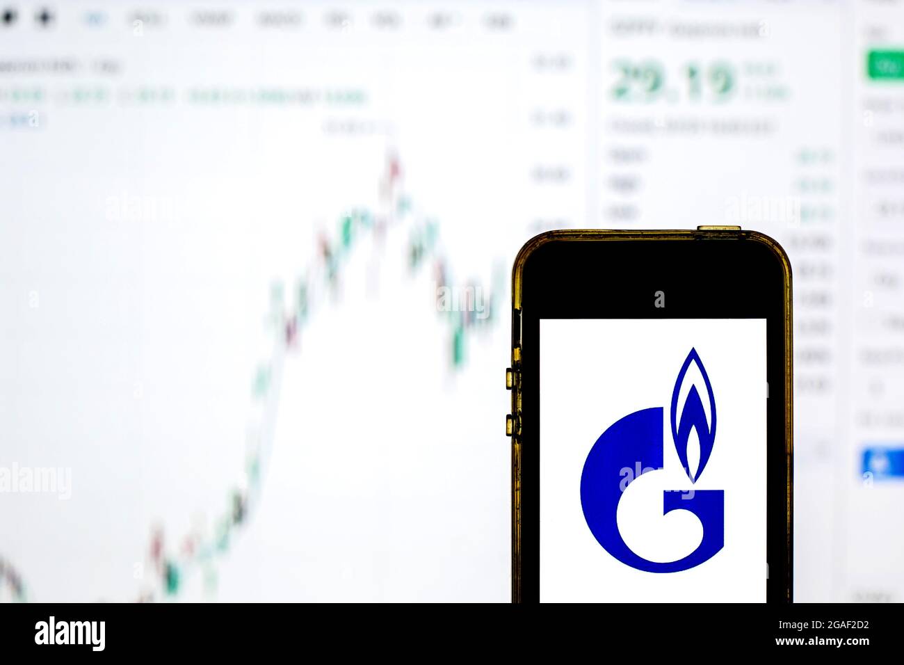 In dieser Abbildung ist ein Gazprom-Logo auf einem Smartphone mit den Börseninformationen von Gazprom im Hintergrund zu sehen. Stockfoto