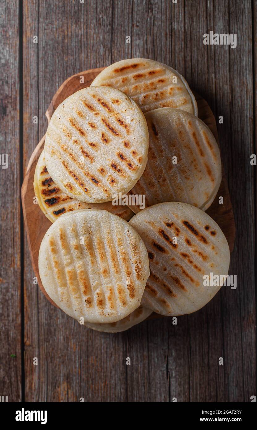 Arepa ist eine Art Mahlzeit aus gemahlenem Maisteig, Maismehl, Draufsicht, Holzhintergrund Stockfoto