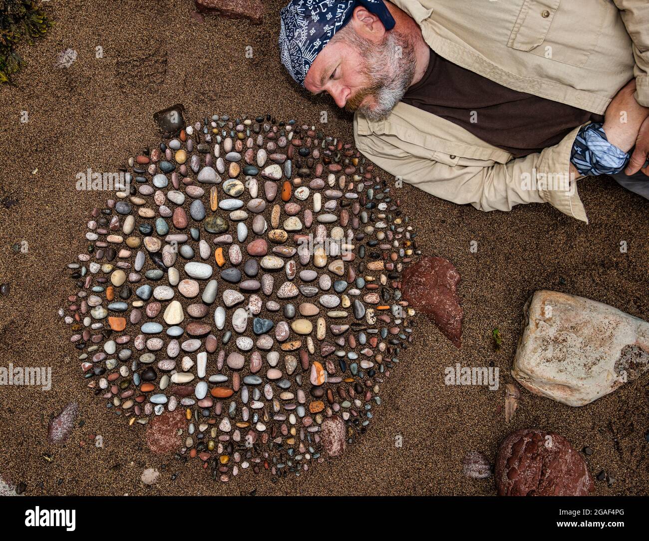 Der Landkünstler James Brunt kreiert am Strand, Dunbar, East Lothian, Schottland, Großbritannien, eine Stein- oder Felsskulptur Stockfoto