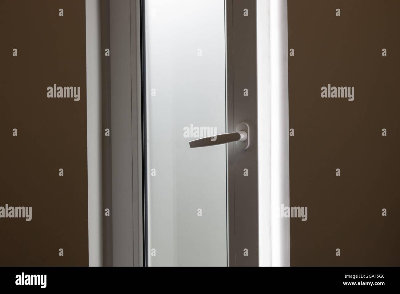 Das Fenster im Badezimmer war aus Milchglas, es schien zwar hell, aber man konnte es nicht sehen, das Konzept der Privatsphäre. Stockfoto