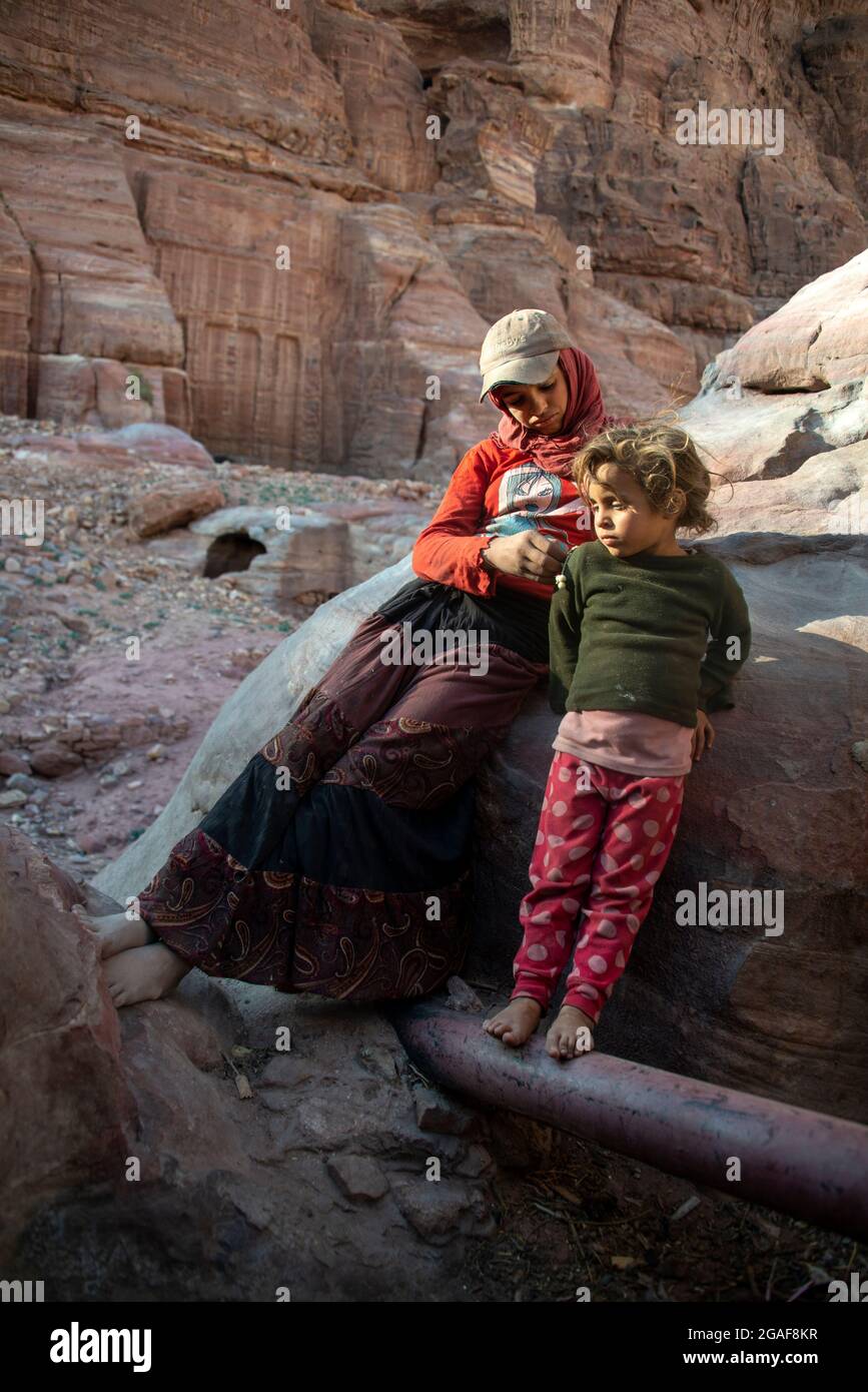 Junge Beduinen entspannen sich in der Nähe ihrer Höhle in Petra, Jordanien Stockfoto