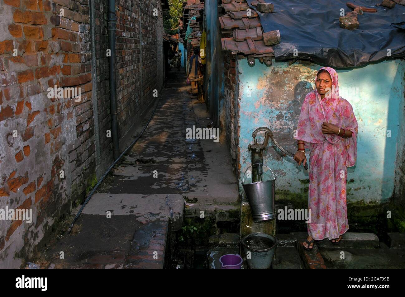 Frauen, die in Kalkutta, Indien, eine Pumpe für Wasser verwenden Stockfoto