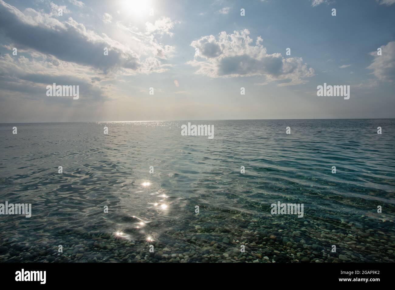 Idyllische Aussicht auf stilles Wasser und Sonne und Wolken - wunderbare Entspannung am Mittelmeer (oder Schwarzes Meer) - Zen-ähnliche Aussicht und Platz für Vacati Stockfoto