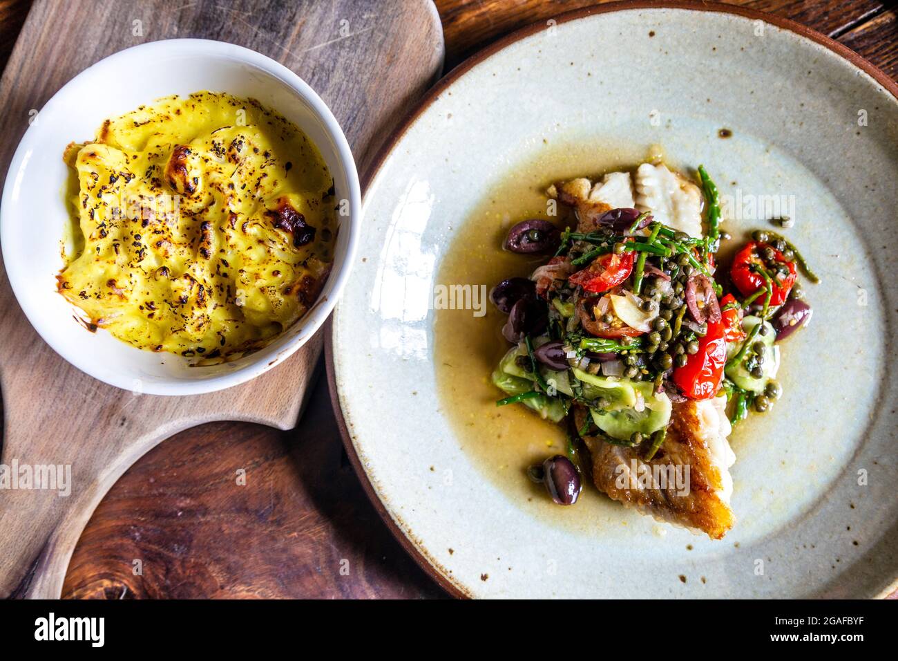 Ray Wing mit Samphire, Oliven, Tomaten und Kapern mit Blumenkohlenkäse im Gurnard's Head Pub, Zennor, Cornwall, Großbritannien Stockfoto